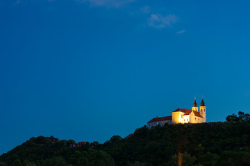 Poster - Tihany Benedictine abbey in yellow light at the blue hour in Tihany, Hungary