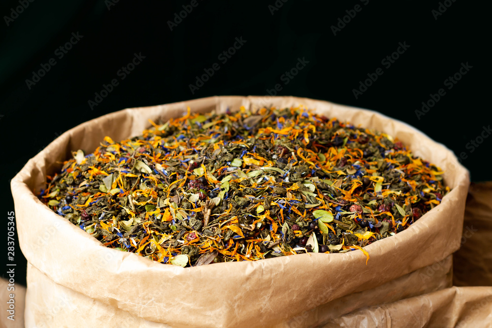 a mixture of dried herbs (tea and flowers leaves) for brewing herbal tea, in a paper bag