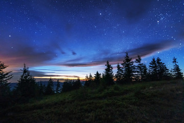 Wall Mural - fantastic starry night with galaxy milky way with a tourist and a tent on the mountain range in the 