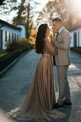 Lifestyle of young couple in love hugging. Pretty young girl in  elegant dress and her handsome boyfriend in a grey suit. Romantic mood.  Love story. To love each other. Happy moments of life