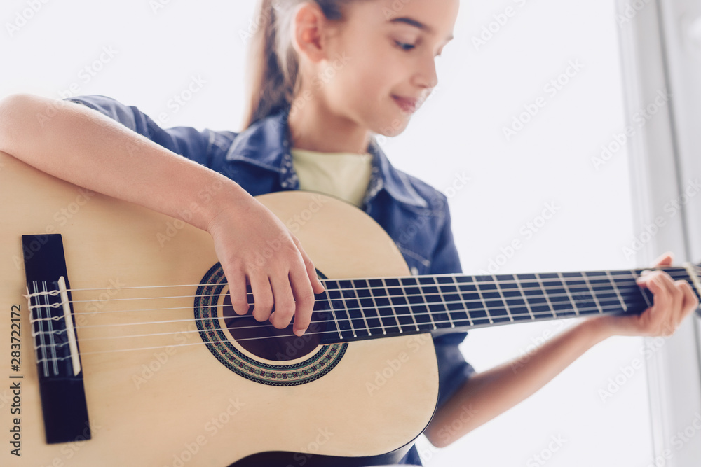 Girl learning to play guitar - obrazy, fototapety, plakaty 