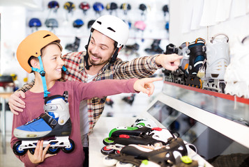 Wall Mural - father and son deciding on new roller-skates in sports store