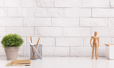 Wall Mural - Table with stationery and wooden mannequin in modern office