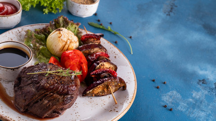 Canvas Print - Medium rare  beef steak with herbs and grilled vegetables. Copy space