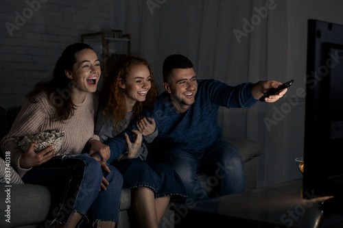 Fotografía Excited friends watching TV and switching channels