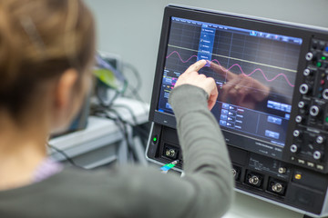 Female scientist doing research in a quantum optics lab (color toned image)