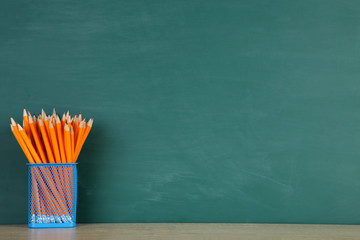 Wall Mural - Pencils in basket on green background