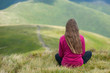 © Андрей Репетий - Young fitness woman meditating at mountain peak while enjoying a beautiful landscape of mountains.