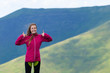 © Андрей Репетий - Happy smiling woman hiker in mountains showing thumbs up.
