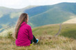 © Андрей Репетий - Young hiker girl relaxing in the mountains and admiring the landskape.