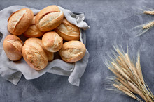 Bread Buns In Basket On Rustic Wood With Wheat Ears, Top View On Grey