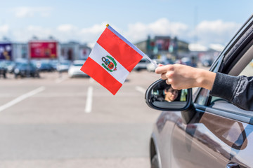 Wall Mural - Boy holding Peru Flag from the open car window the parking of the shopping mall. Concept