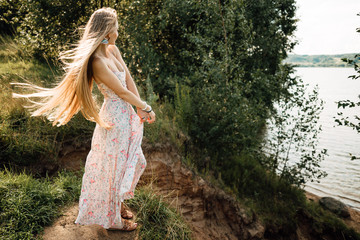 beautiful young girl with long hair in dress outdoors, cute woman walking in the park