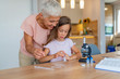 © Dragana Gordic - Girl and her grandmother doing scientific experiment. Preparation for scientific experiment with my grandmother. Portrait of happy girl and her grandmother at home
