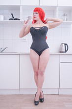 Girl In Black Corset With Red Hair Holding Fork In White Kitchen