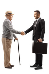 Wall Mural - Elderly gentleman shaking hands with a young man in a suit with a briefcase