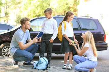 Sticker - Parents getting their children ready for school outdoors