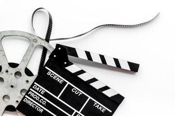 Movie premiere concept with clapperboard, film type on white background top view