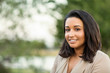 © digitalskillet1 - Young confident happy Hispanic woman smiling outside.