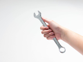 A hand is holding ring spanner on white background.