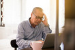 © gballgiggs - Senior asian elderly man having migraine and headache pain while working at home,Elderly healthy concept