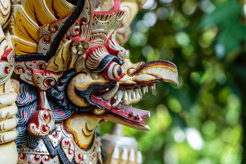 Wall Mural - Balinese ancient colorful bird god Garuda with wings, closeup. Religious traditional statue from wood. Wooden old curved figure of Hindu god in Island Bali, Ubud, Indonesia