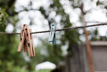 Colorful Plastic Clothespins On The Hangers With Blurred Background