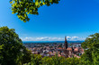 Germany, Above roofs and ancient gothic minster building of popular student city freiburg im breisgau in summer under a green tree withour scaffolding in 2019