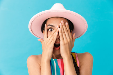 Wall Mural - Image closeup of excited caucasian woman wearing hat covering her face and looking at camera