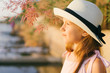 Pretty little girl with long beautiful hair in a straw hat and a pink dress in a summer beach. Sunny day, sunset.