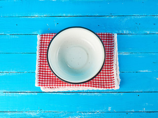 empty round white metal plate on a red-white textile napkin