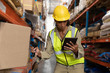 © wavebreak3 - Female worker scanning package with barcode scanner while using digital tablet in warehouse
