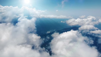 Wall Mural - Flying through heavenly beautiful sunny cloudscape. Picturesque timelapse of white fluffy clouds moving softly on the clear blue sky in pure sunshine. Direct view from the cockpit.