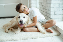 A Child With A Dog. Teen Boy With A Dog At Home. 