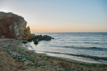 Wild Beach with cliff and seaweed at the Black Sea before dawn