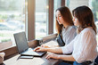 © Ihor - Two oung women working on a laptop at the coffee shop together, copy space. Female friends browsing online on a computer at the cafe