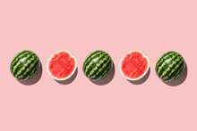 Row Of Fresh Watermelon In Center On Pink Backgrond. Top View