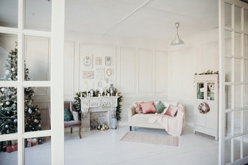 beautiful modern design of the room in delicate light colors decorated with Christmas tree and decorative elements