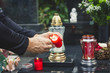 Lighting candle at graveyard during All Souls Day. Dedicated honor to all nearest dead people