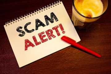 Poster - Words writing texts Scam Alert Motivational Call. Business concept for Safety warning to avoid fraud or virus attacksNotebook page black red letters pen ideas messages wooden table glass drink