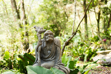 stone ruined Arhat statue in forest