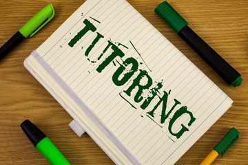 Poster - Text sign showing Tutoring. Conceptual photo Mentoring Teaching Instructing Preparing Supporting Give lessons written Notebook Book the wooden background Pen and Markers next to it.