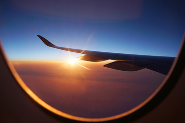 Wall Mural - sunlight through airplane window from wing during sunrise