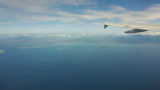 Fototapeta  - Blue sea or ocean in it and small tropical islands. Looking through window aircraft during flight