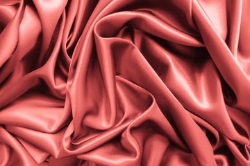  Smooth elegant wavy coral pink satin silk luxury cloth fabric texture, abstract background design.