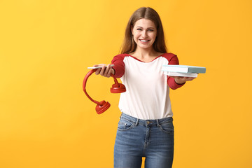 Sticker - Young woman with books, mobile phone and headphones on color background. Concept of choosing between reading and listening to audiobook