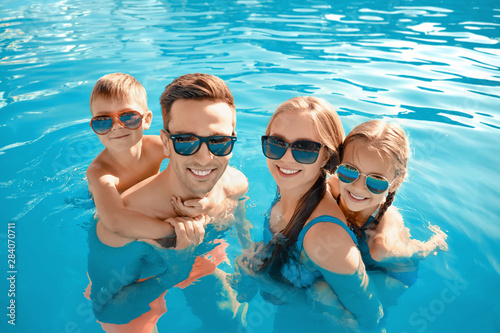 Fotografía Happy family in swimming pool on summer day