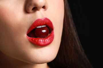 Canvas Print - Beautiful young woman with cherry in mouth, closeup