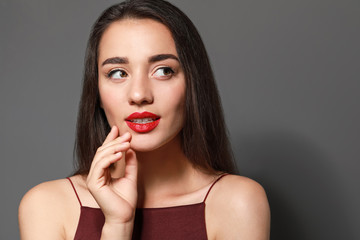 Sticker - Beautiful young woman with bright lipstick on grey background