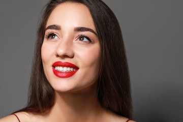 Canvas Print - Beautiful young woman with bright lipstick on grey background